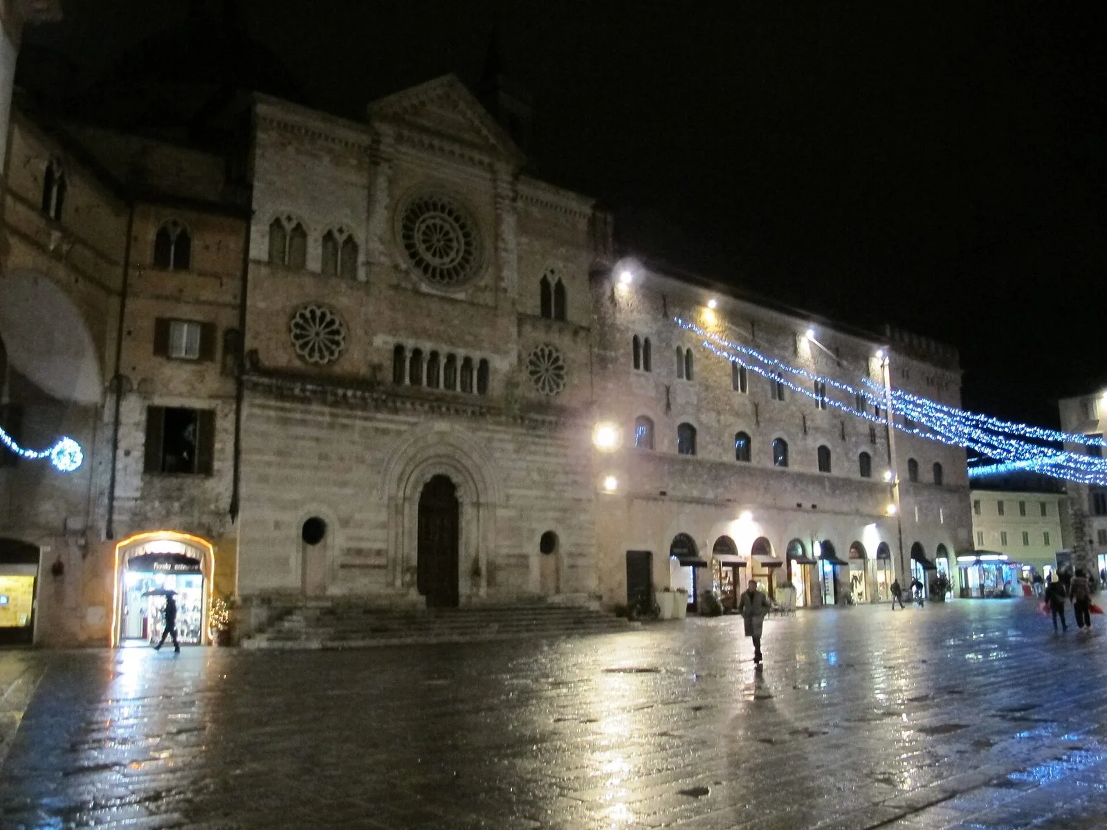 Piazza della Repubblica a Foligno di sera, con la facciata del Duomo di San Feliciano e le luci sul selciato bagnato