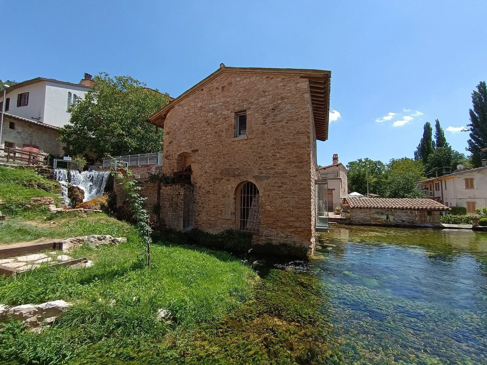 Antico mulino in pietra sul canale d'acqua limpida di Rasiglia in una giornata di sole